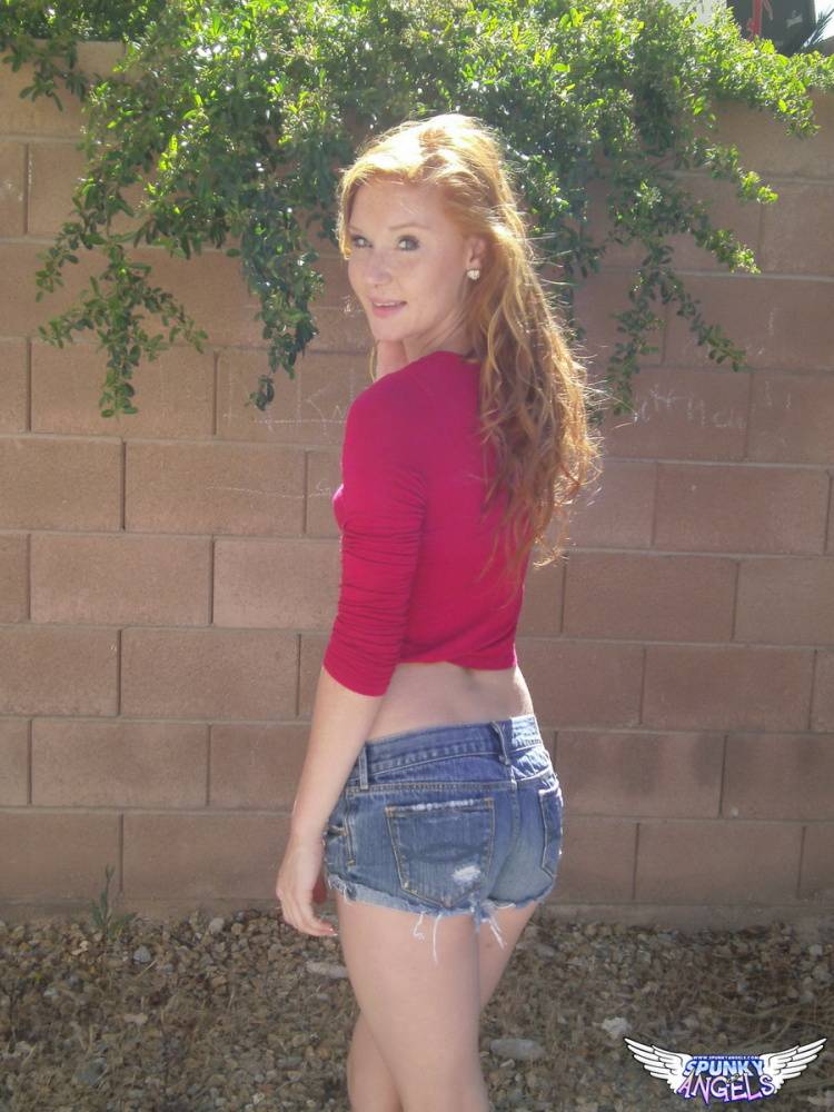 Hot redhead Alex Tanner flashes her tiny tits outdoors and drops her shorts - #12