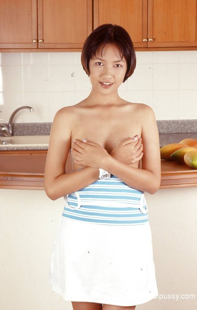 Clothed Asian with tiny tits is posing in the kitchen with spread legs - #10