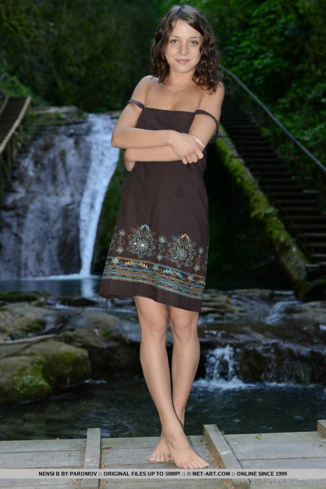 Sweet teen Nensi B models naked on wooden bridge afore waterfall - #12