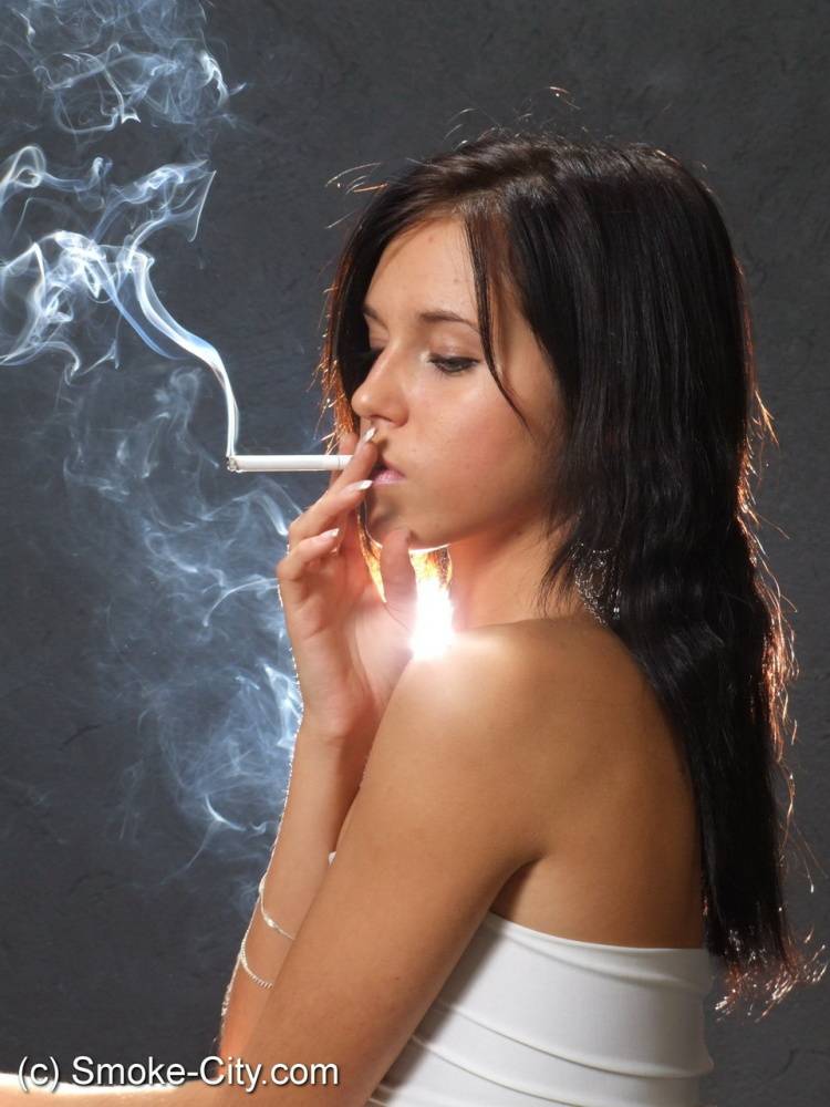 Young brunette smokes a cigarette while wrapped in tight white dress and heels - #2
