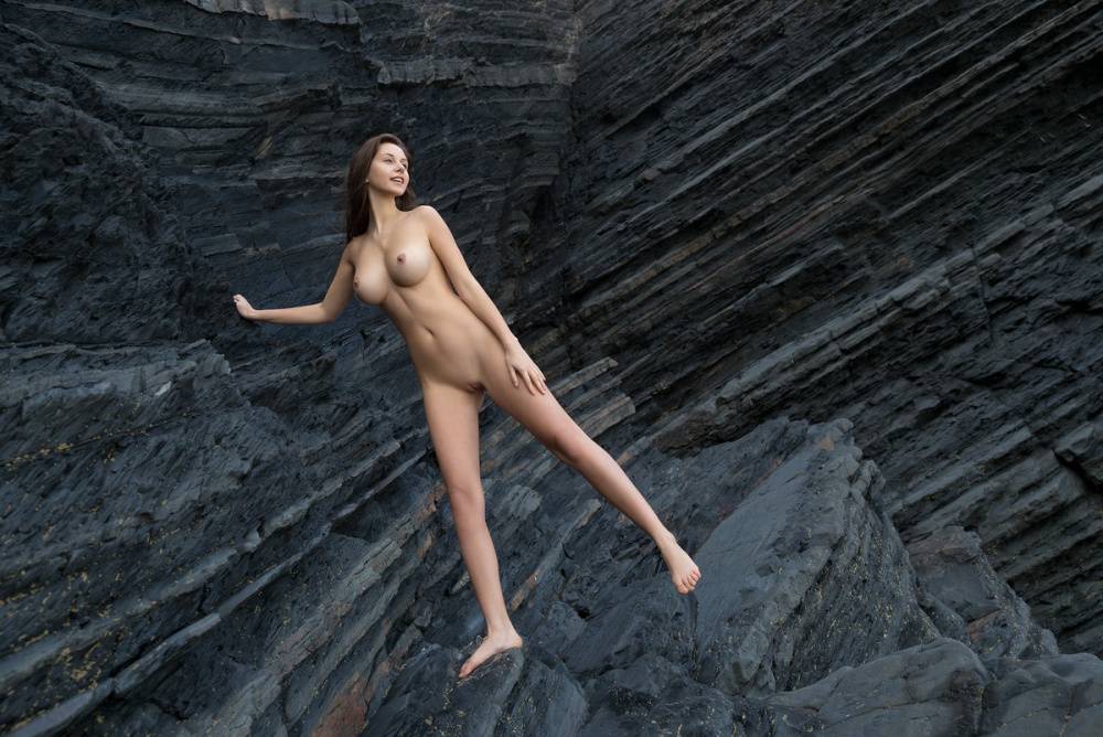 Totally naked girl Alisa I models up against a sea cliff during solo action - #7