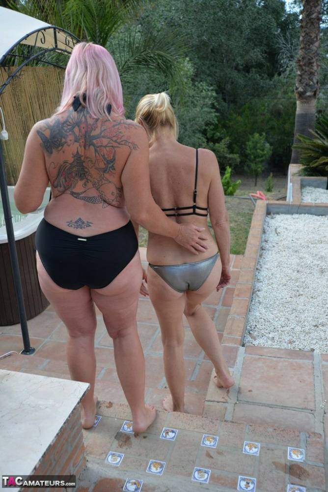 Mature amateurs share a lesbian kiss in their swimwear on poolside patio - #8