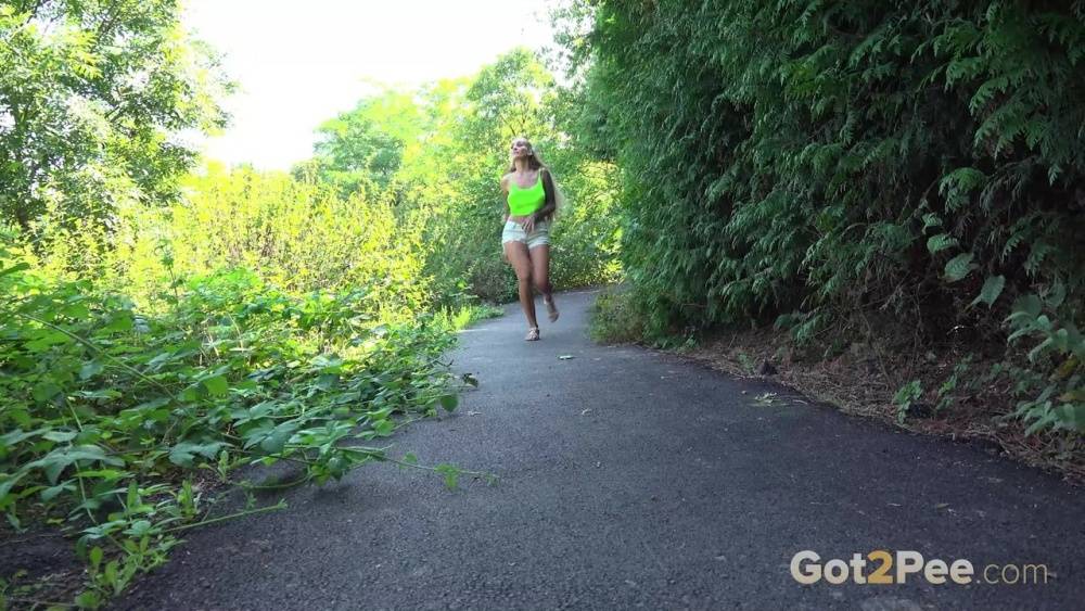 Blonde teen Daisy Lee takes a piss on a paved path through the woods - #8