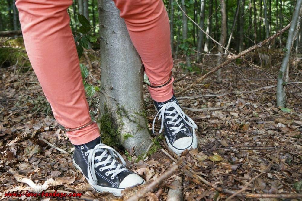 Clothed girl in canvas sneakers finds herself handcuffed to a tree in woods - #6