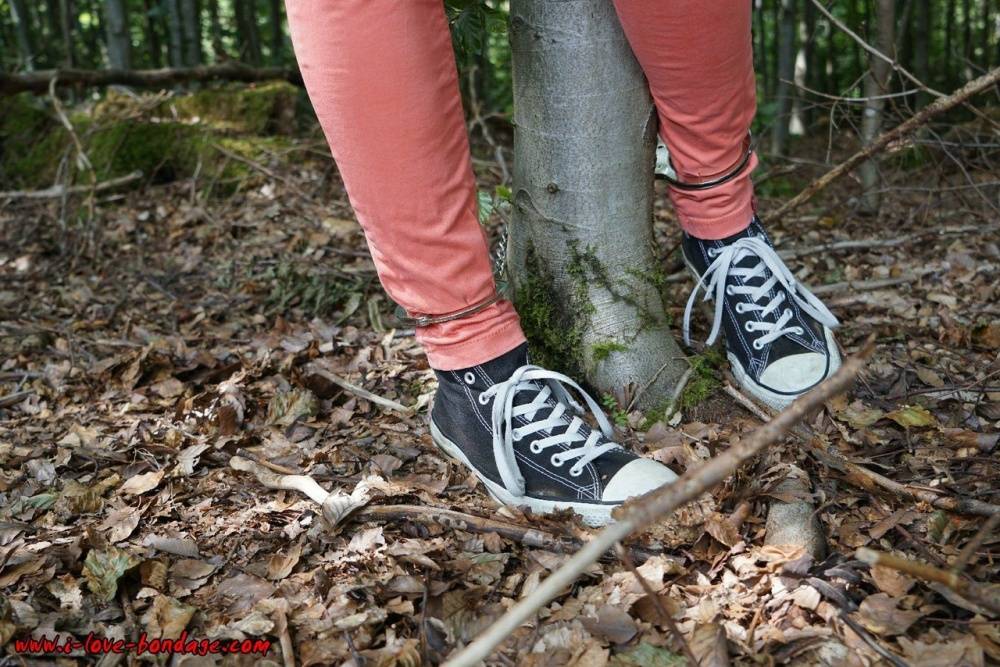Clothed girl in canvas sneakers finds herself handcuffed to a tree in woods - #11
