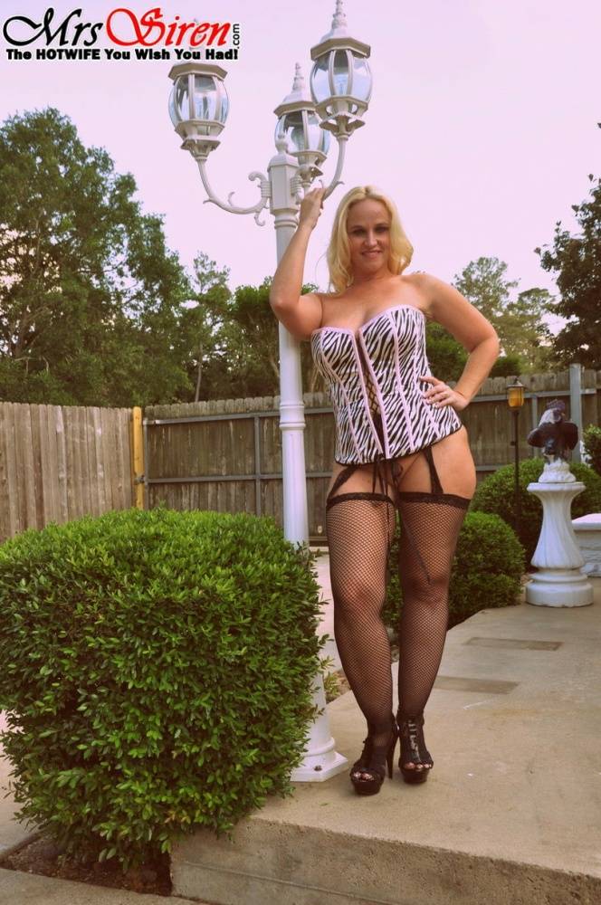Blonde amateur Dee Siren models a laced corset and mesh hosiery in a backyard - #1