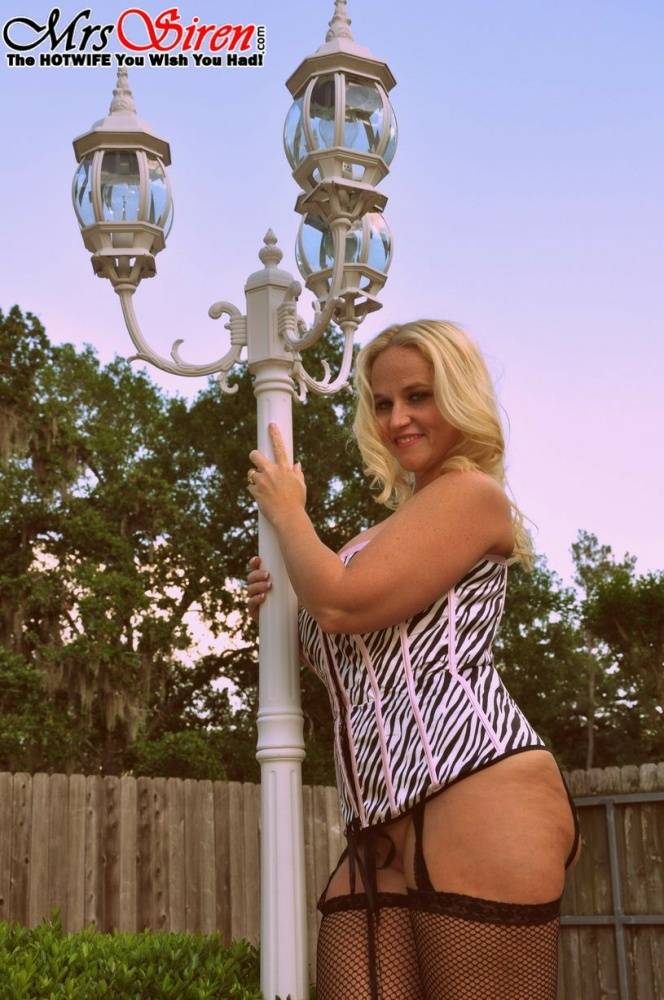 Blonde amateur Dee Siren models a laced corset and mesh hosiery in a backyard - #16