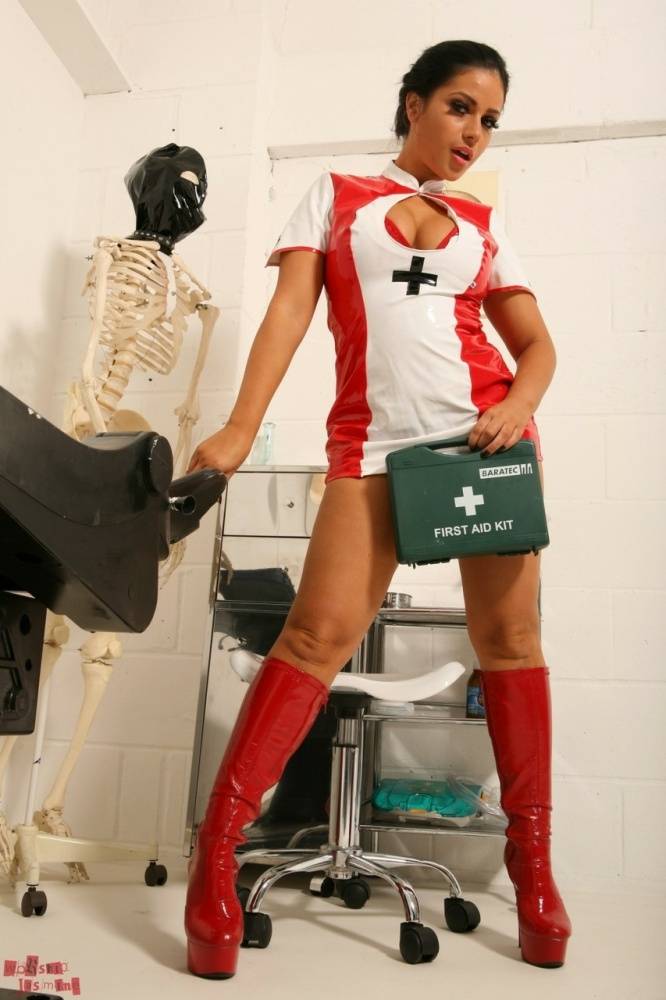 Middle-aged model Jasmine Jones poses in a latex nurse outfit and red boots - #11