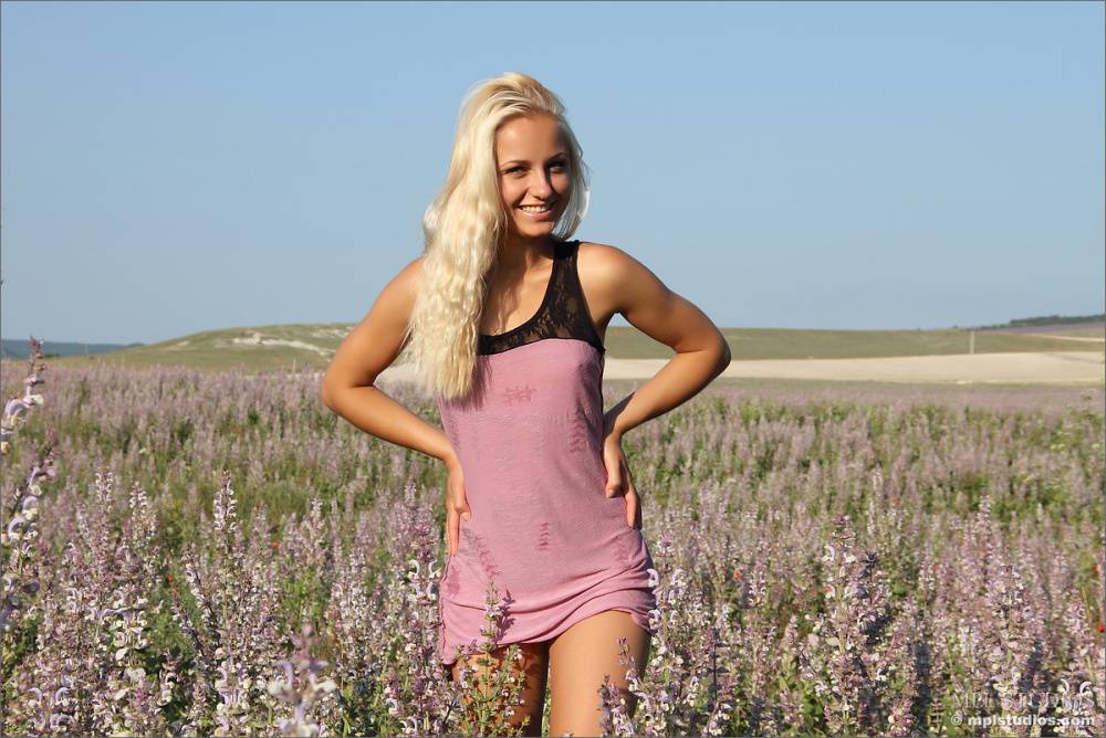 Smiling blonde slut loses her mini dress to romp naked in a field of flowers - #1