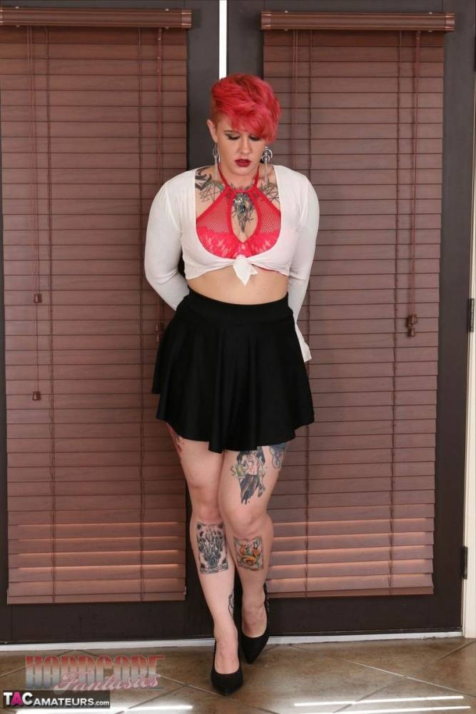 Tattooed model squats in a black miniskirt while sporting a punk haircut - #10