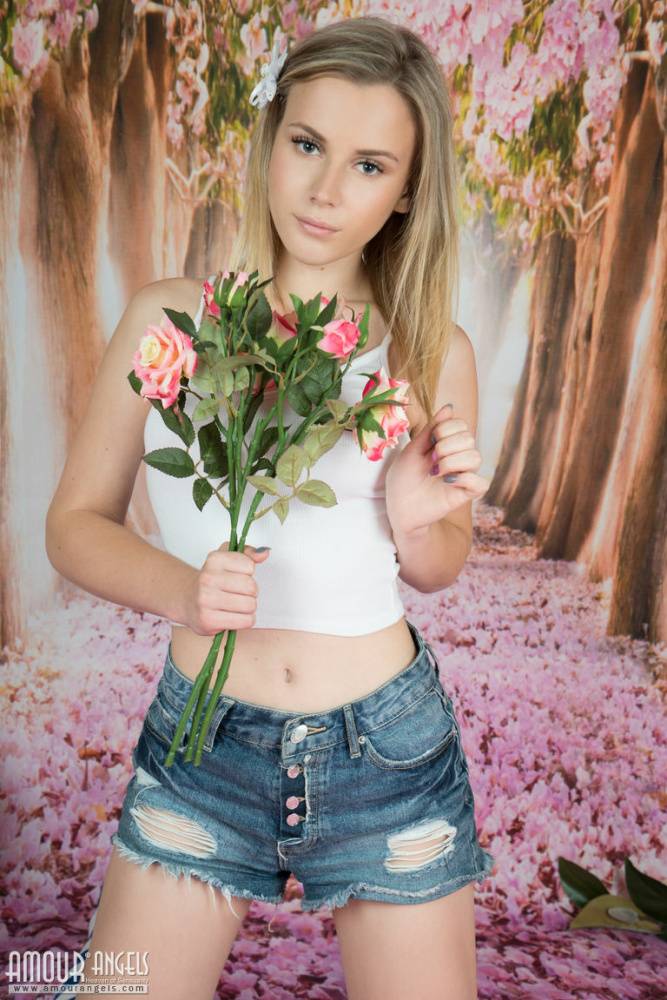 Young looking girl puts down a bunch of flowers before getting totally naked - #5