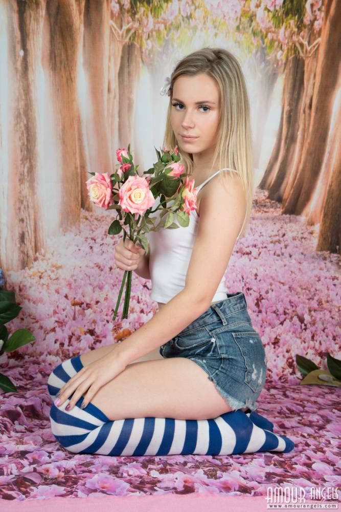 Young looking girl puts down a bunch of flowers before getting totally naked - #7