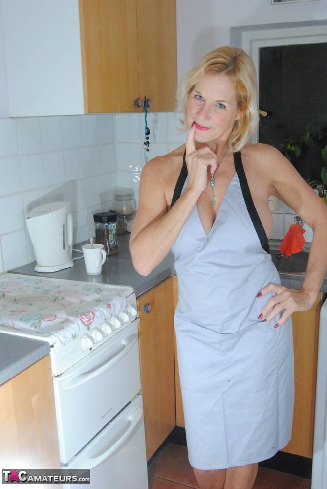 Mature MILF with blonde hair wears only an apron while devouring a banana - #3