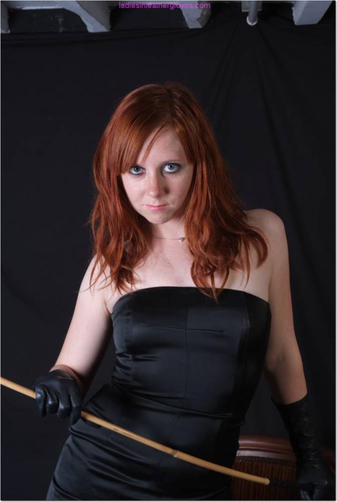 Natural redhead holds a cane with leather gloves while exposing her pink slit - #13