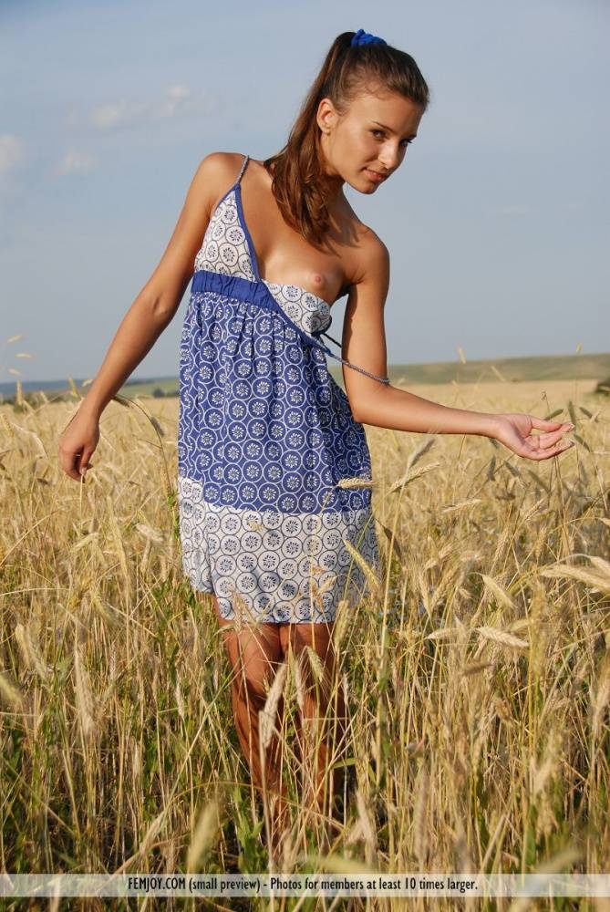 Petite teen Nikki D undresses to model naked in a field of hay - #13