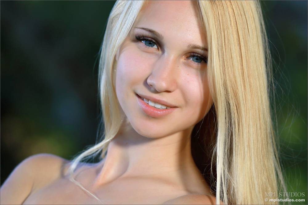 Naked blond girl prances about the grassy perimeter of a forest - #10