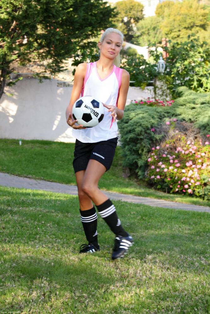 Skinny blonde girl uncovers tiny tits while bouncing a soccer ball outdoors - #1