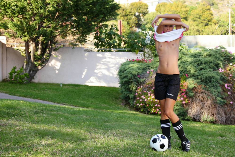 Skinny blonde girl uncovers tiny tits while bouncing a soccer ball outdoors - #11