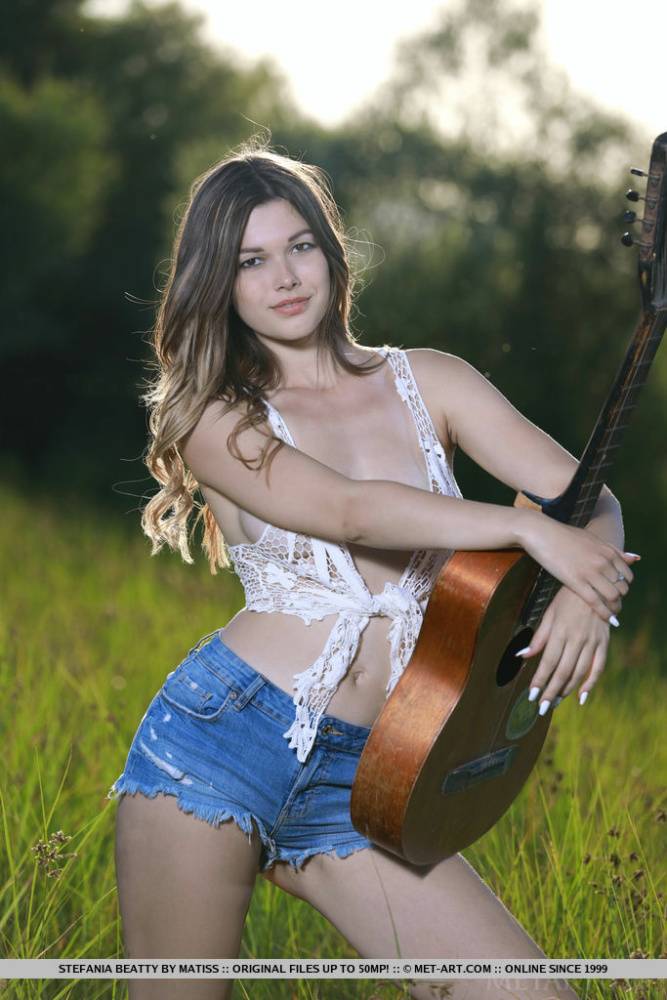 Nice teen Stefania Beatty gets totally naked in a field while playing guitar - #11