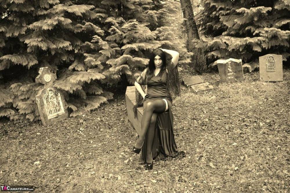 Goth girl Barby Slut bares her big tits and twat atop a casket in the woods - #4