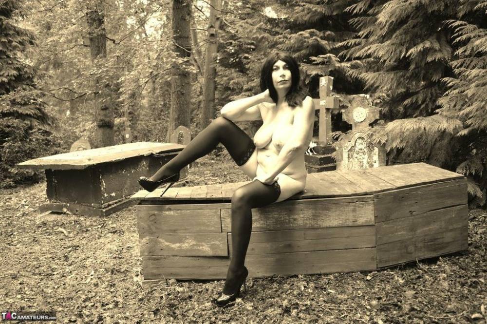 Goth girl Barby Slut bares her big tits and twat atop a casket in the woods - #2