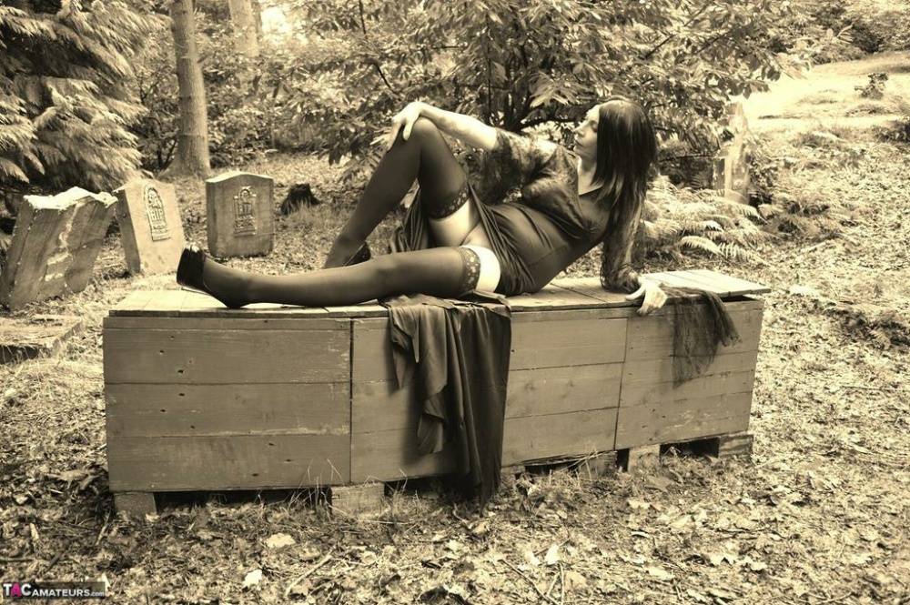 Goth girl Barby Slut bares her big tits and twat atop a casket in the woods - #8