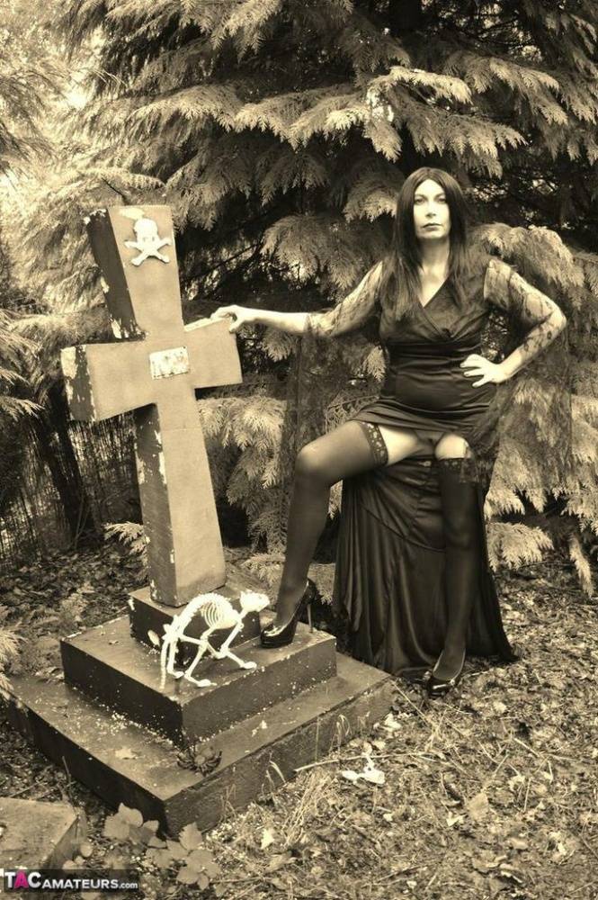 Goth girl Barby Slut bares her big tits and twat atop a casket in the woods - #9