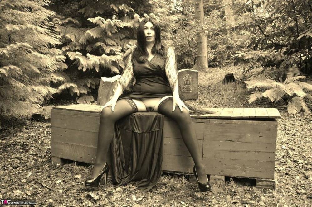 Goth girl Barby Slut bares her big tits and twat atop a casket in the woods - #13