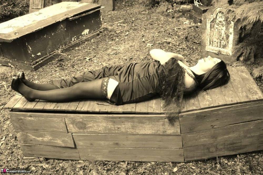 Goth girl Barby Slut bares her big tits and twat atop a casket in the woods - #3
