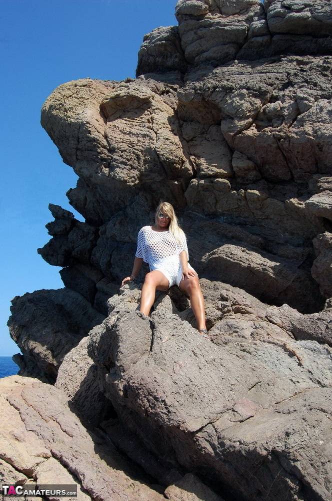 Blonde amateur Sweet Susi exposes her tits and ass on a rocks by the sea - #1
