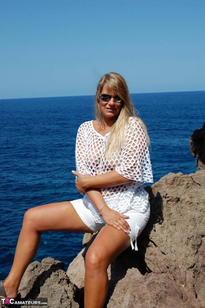 Blonde amateur Sweet Susi exposes her tits and ass on a rocks by the sea - #8