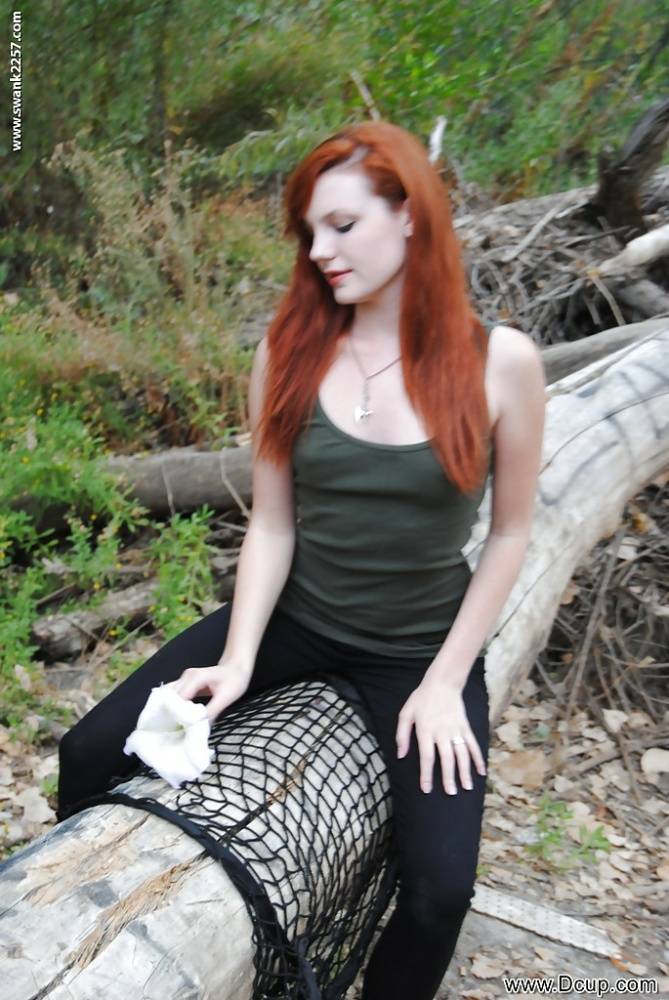 Young redhead chick Nicci Vice showing off tits and ass in the woods - #16