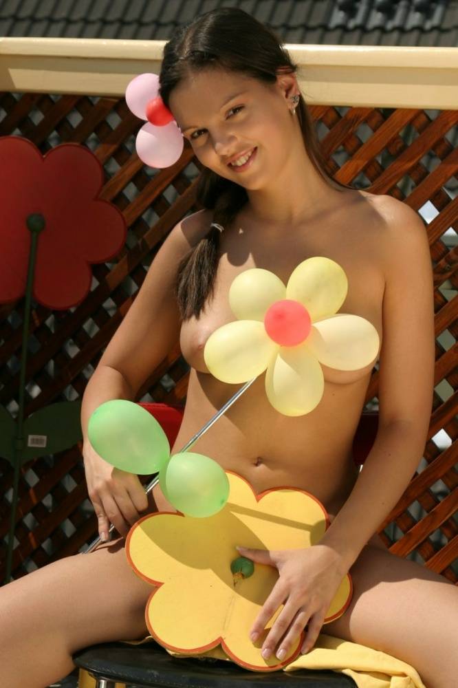 Beautiful girl Sweet Eva gets naked while blowing up balloons on a patio - #15