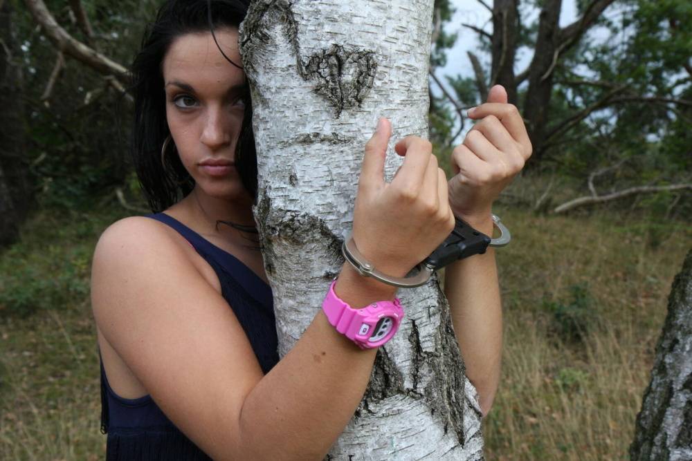 Brunette girl Nora is handcuffed to a tree while wearing a pink G-Shock watch - #13