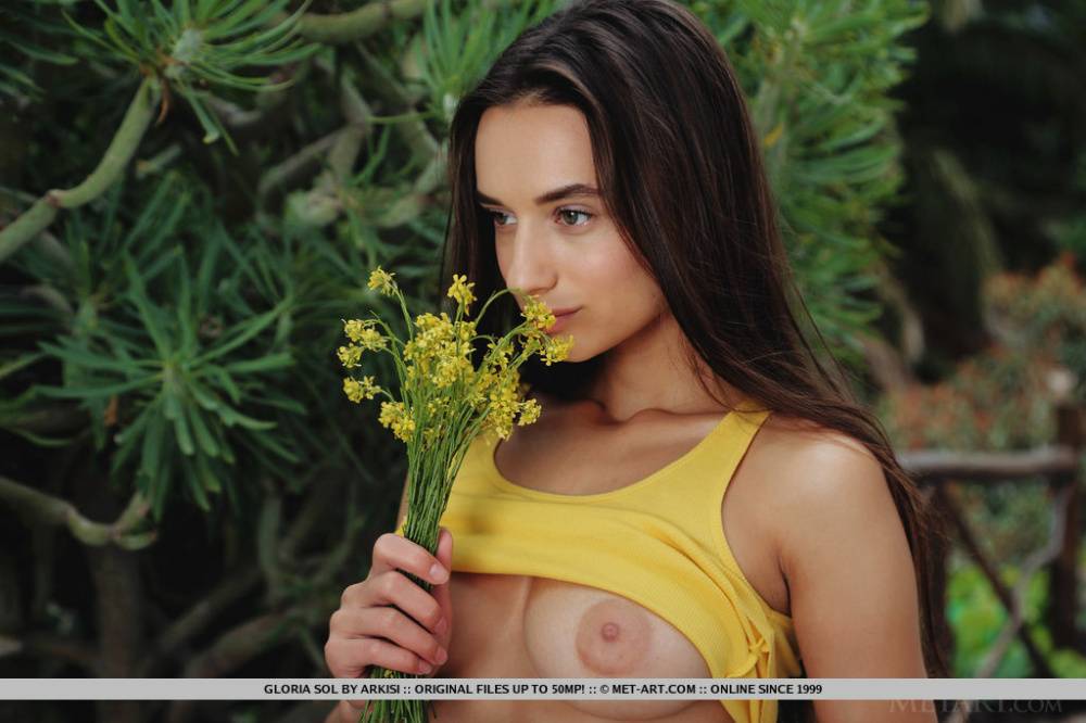 Young brunette Gloria Sol sniffs a bunch of flowers before getting bare naked - #12