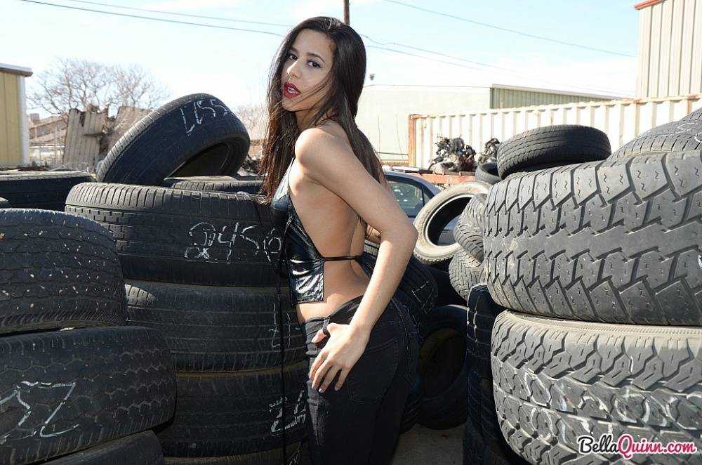 Latina amateur Bella Quinn covers her naked tits with hands amid tire stacks - #10