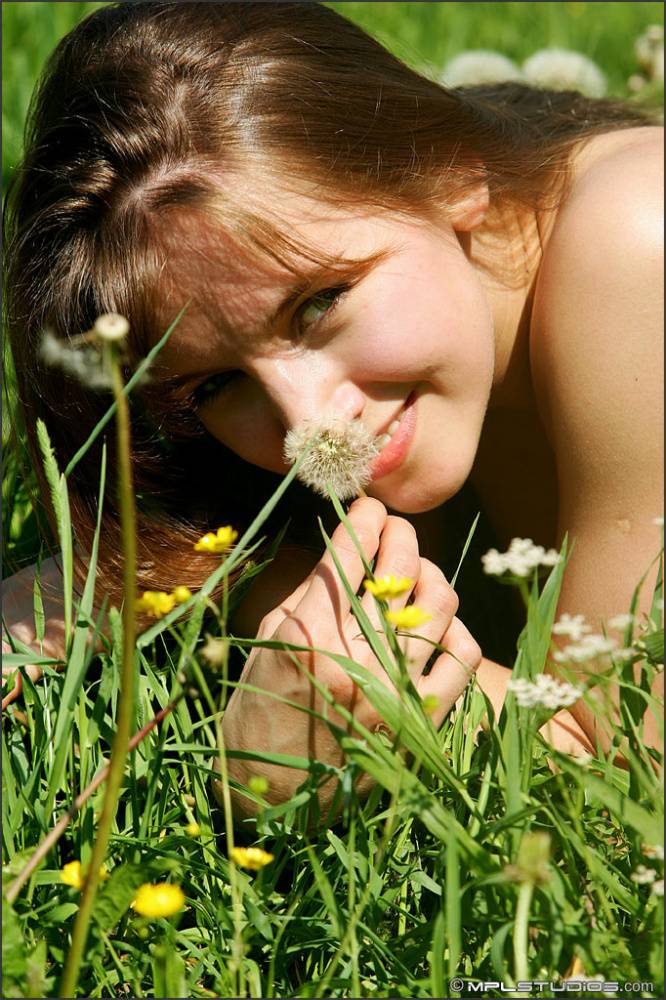 Totally naked girl makes wishes while blowing on dandelions in a field - #8