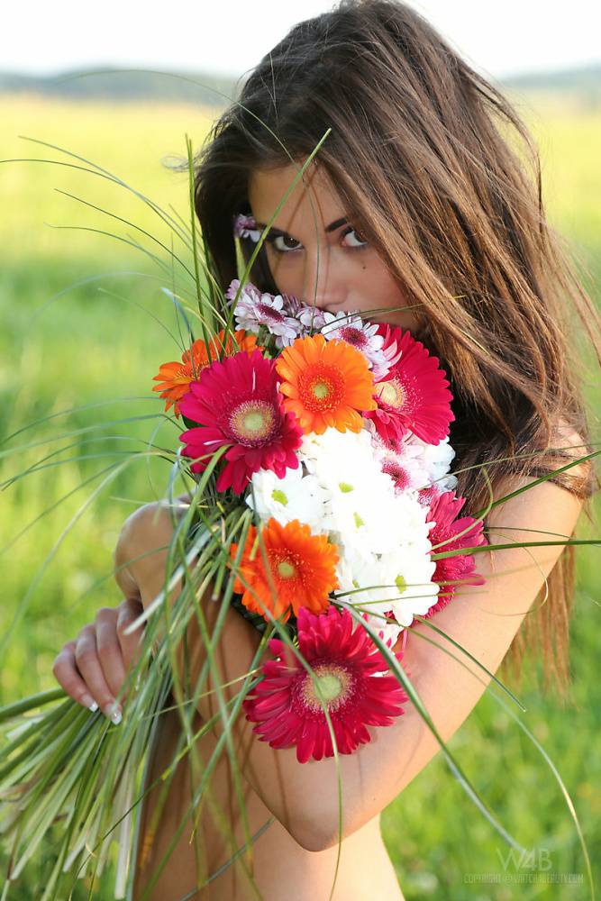 Slim girl Little Caprice holds a bunch of flowers during nude poses in a field - #15