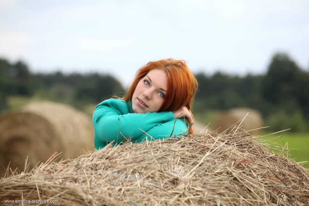 Natural redhead Amber A poses her naked teen body on round bale of hay - #10