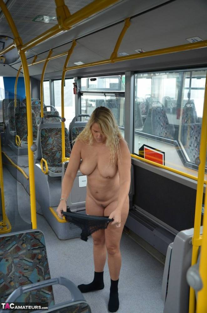 Thick blond chick takes off her underwear to pose naked in socks on a city bus - #1