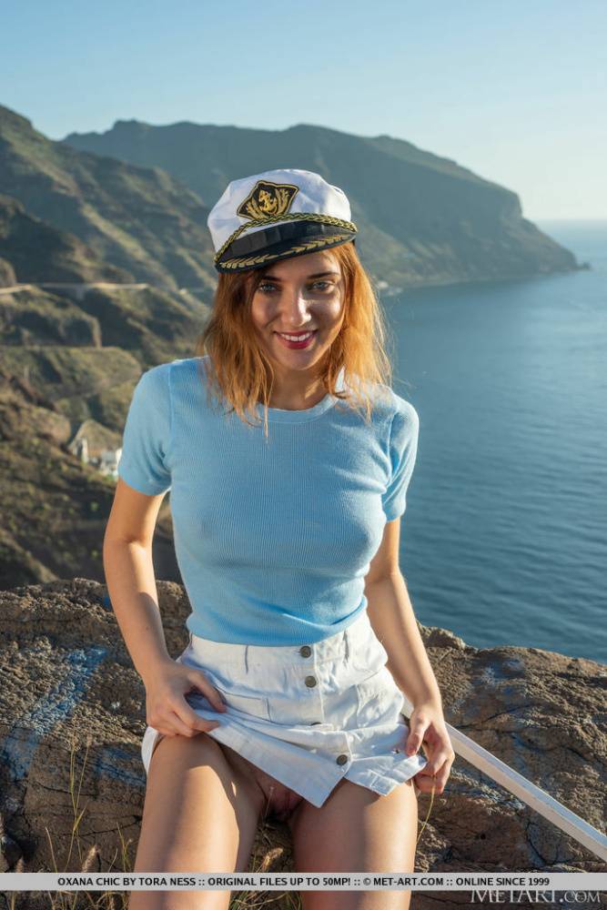 Young redhead Oxana Chic gets naked at a lookout spot in a sailor's hat - #1
