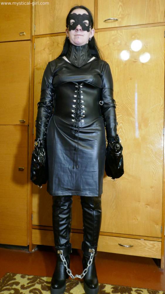 Collared solo woman models leather clothing while wearing a mask - #14