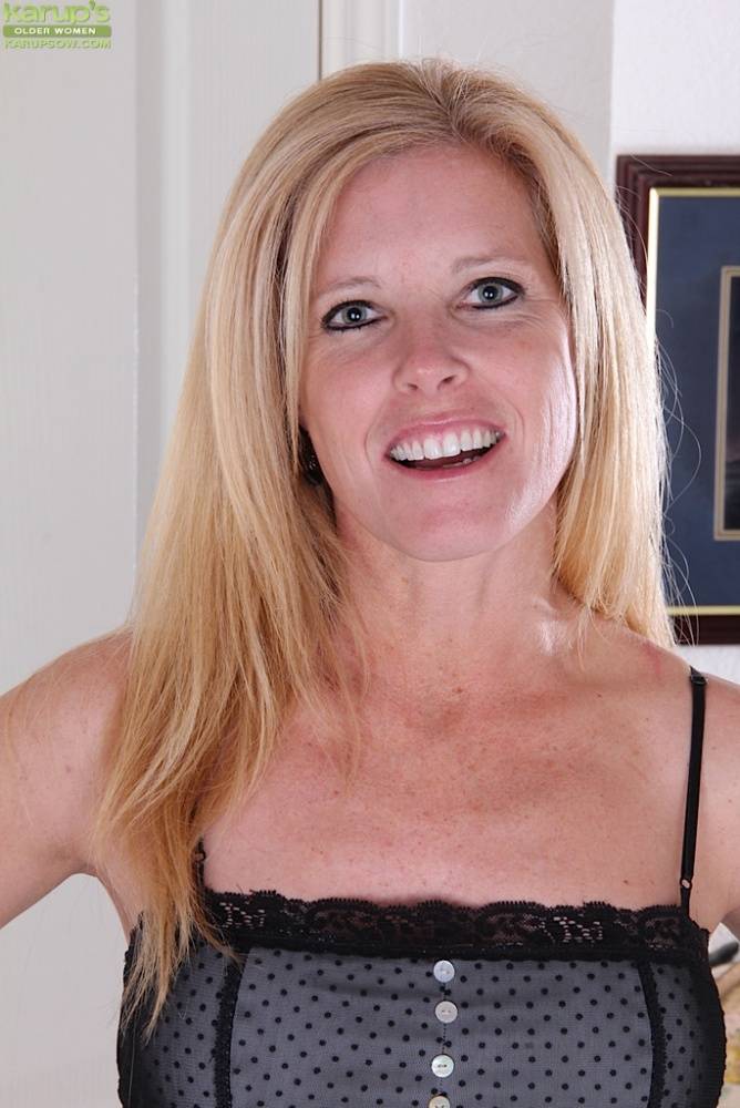 Mature blonde with a nice smile slips off black heels to model totally naked - #11