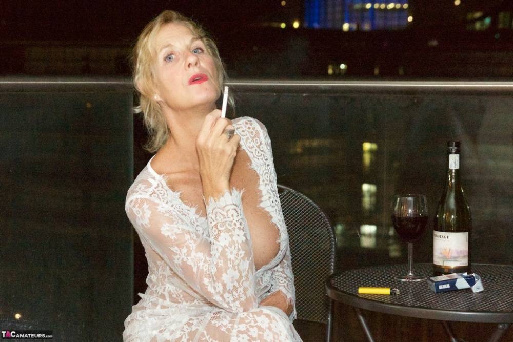 Mature woman Molly MILF works free of lace dress while smoking and drinking - #14
