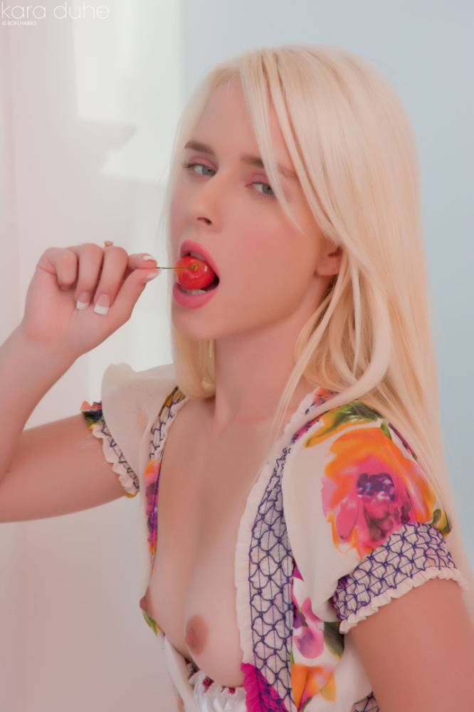 Petite blonde Kara Duhe eating a cherry with her dress open to show tiny tits - #12