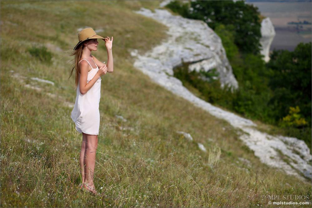 Solo model climbs a hill overlooking the valley to pose in the nude - #3