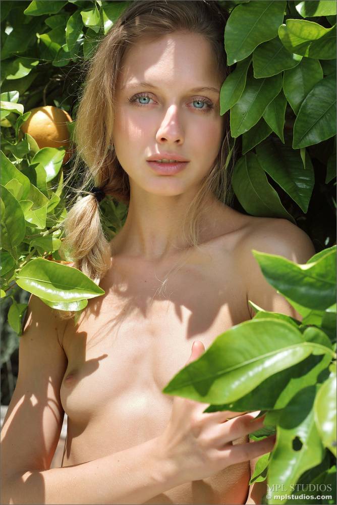 Blonde model juggles oranges before getting totally naked on a patio - #10