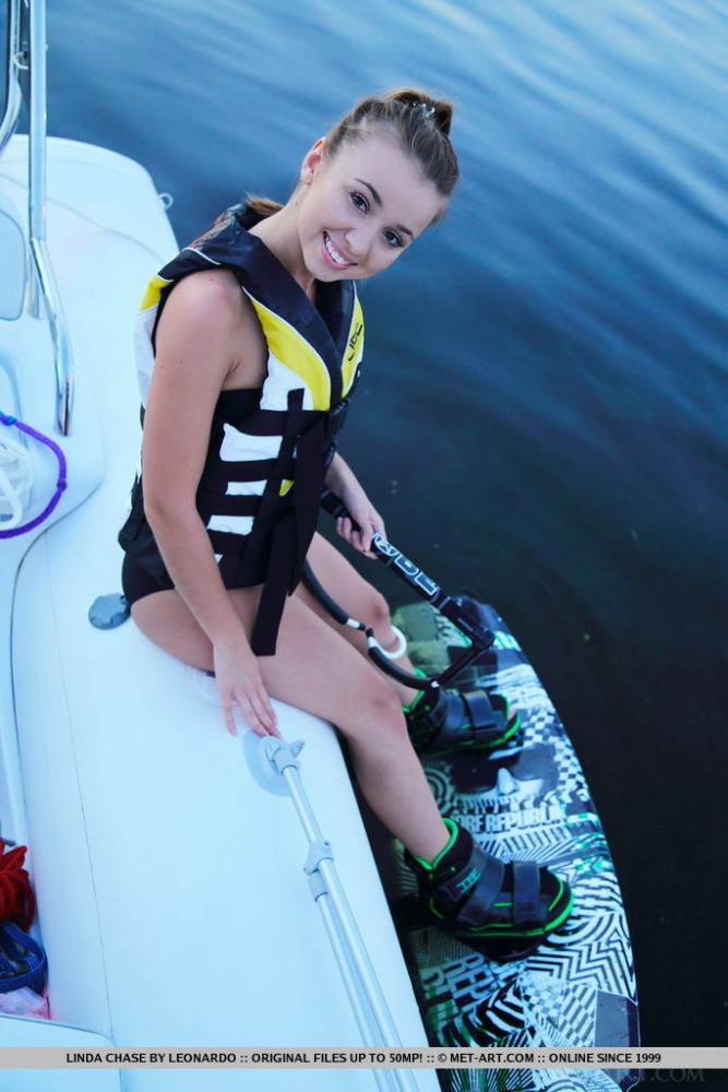 Cute teen Linda Chase takes off a black bikini to pose naked on a boat - #7