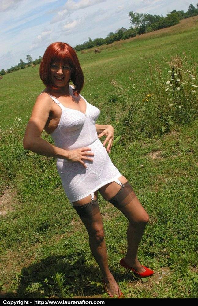 Older redhead Lauren models a retro girdle and nylons in a field - #10
