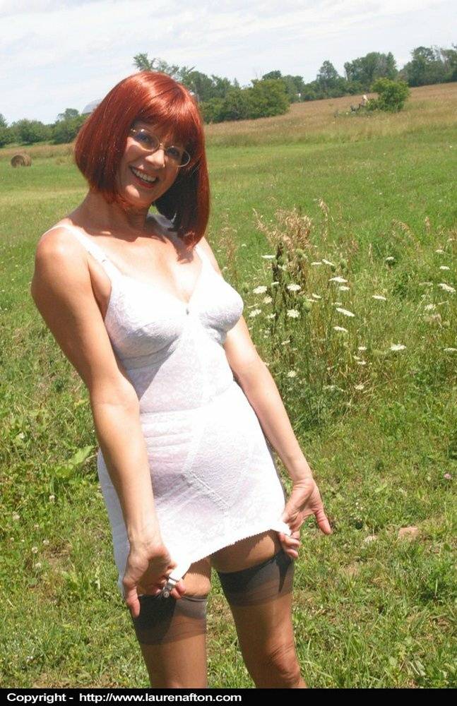 Older redhead Lauren models a retro girdle and nylons in a field - #2